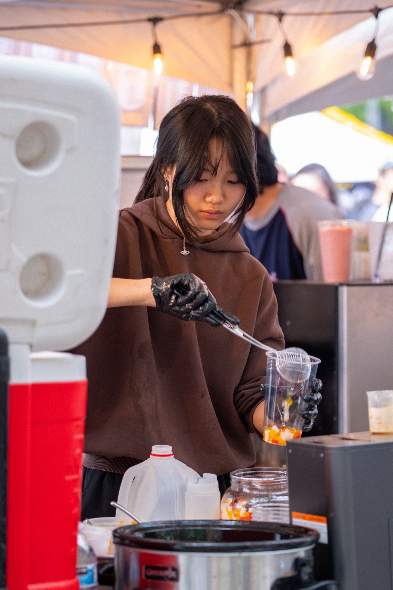 A team member scooping boba into a cup