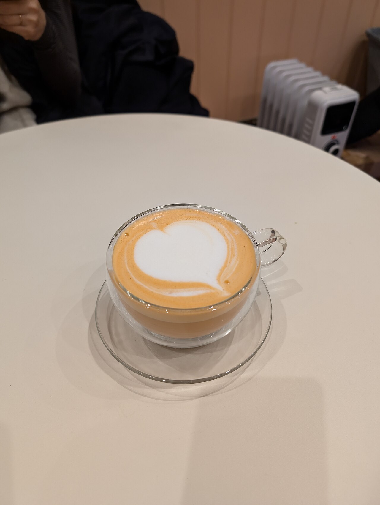 A hot milk tea latte served in a glass cup